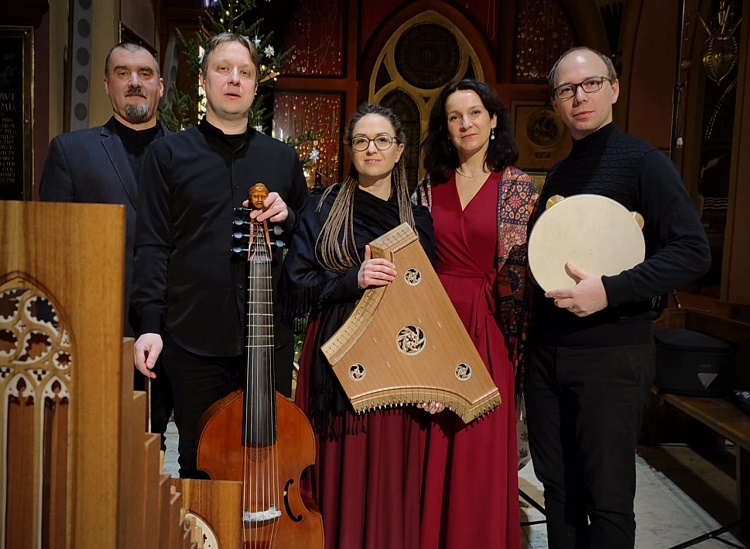 Grupa pięciu muzyków trzymających tradycyjne instrumenty, w tym violę da gamba, psalterium oraz tamburyn, pozuje we wnętrzu o dekoracyjnej architekturze. Zespół Floripari, fot. Maria Molenda
